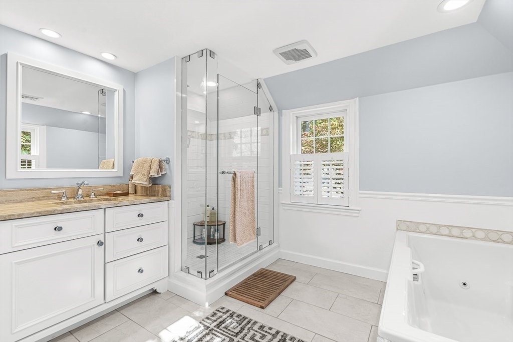 2 Phillips Pond Road, Unit 2 Natick, MA 01760 - Photo 20 of 35 a bathroom with a granite countertop sink a mirror a bathtub and next to a window