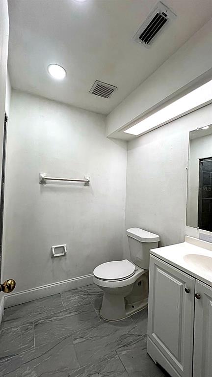 4166 Flying Fortress Avenue Kissimmee, FL 34741 - Photo 9 of 14 a bathroom with a toilet a sink and mirror