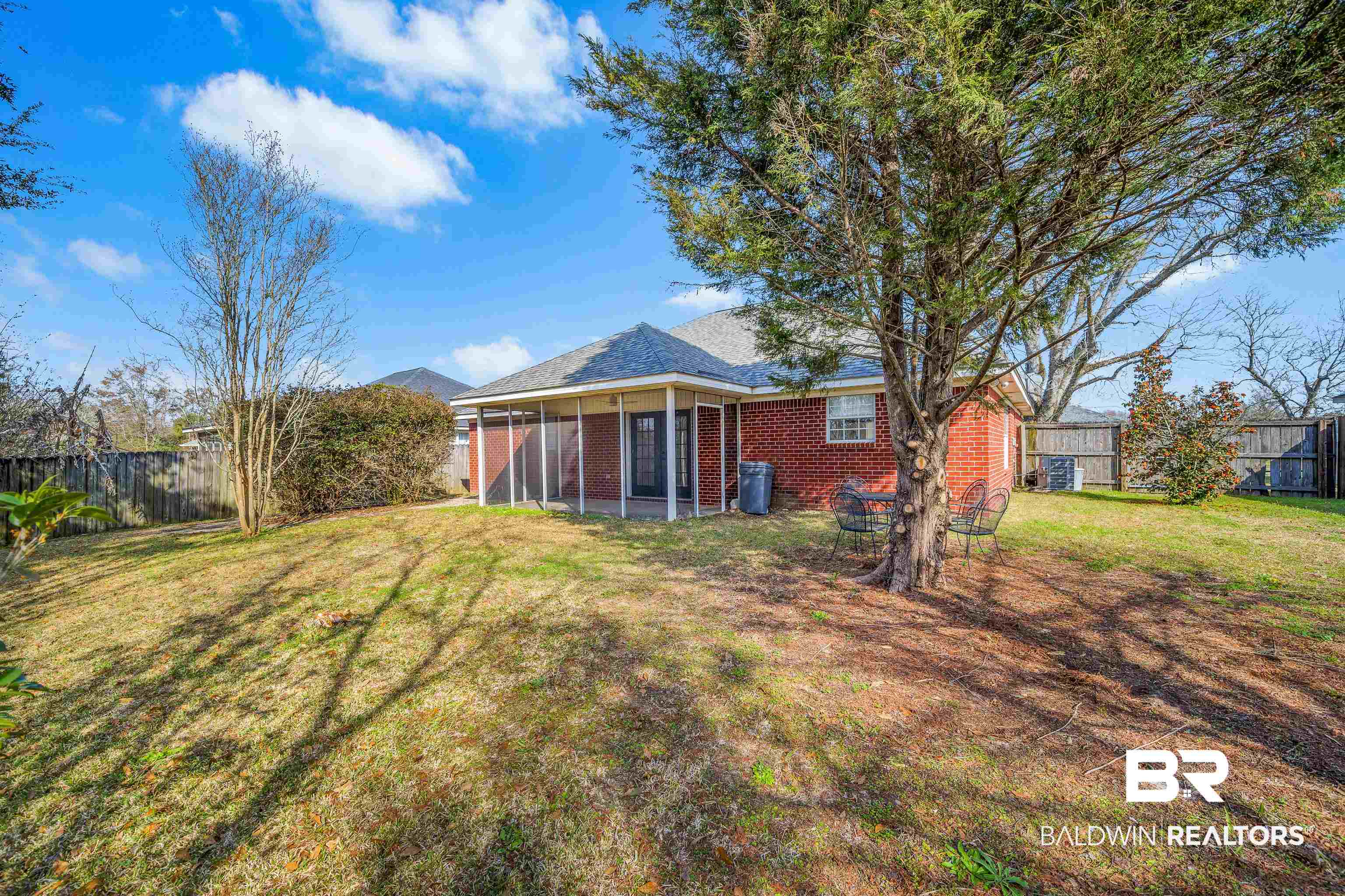 9243 Brookshire Loop Daphne, AL 36526 - Photo 22 of 26 Rear view of house with a yard and a sunroom