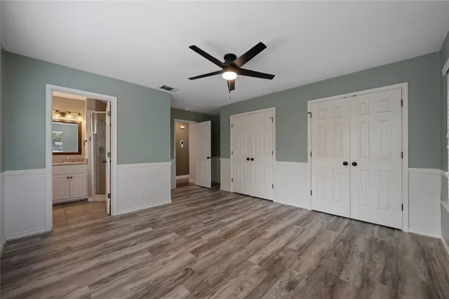 a view of a livingroom with a ceiling fan hardwood floor and a ceiling fan
