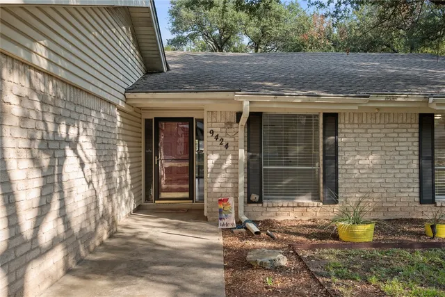 a view of brick house with potted plants