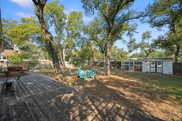 a view of a backyard with a table and chairs and a large tree