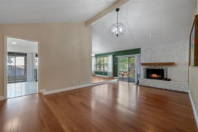 a view of a livingroom with wooden floor fireplace and windows
