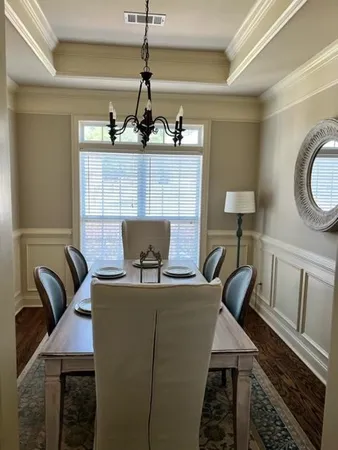 a living room with furniture a dining table and chairs with wooden floor