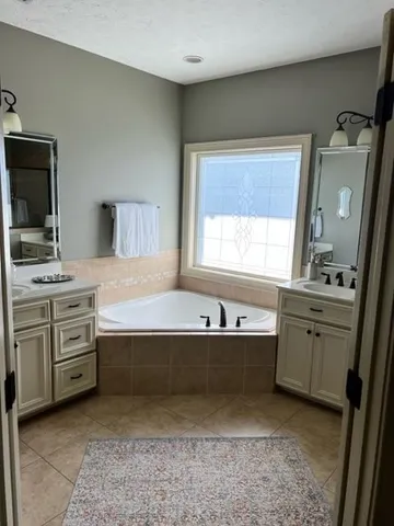 a bathroom with a tub sink and mirror