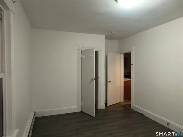 an empty room with wooden floor and closet