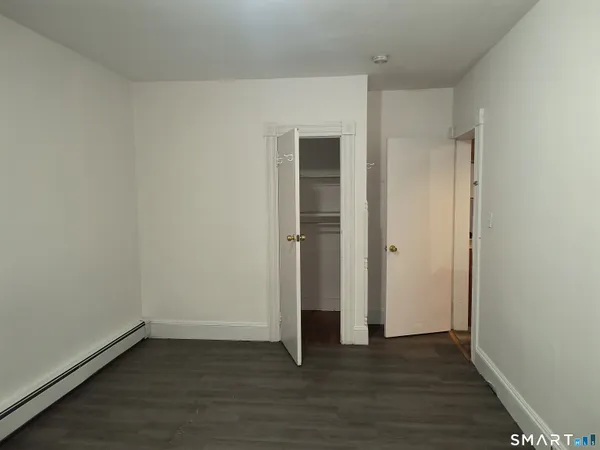 an empty room with wooden floor and closet