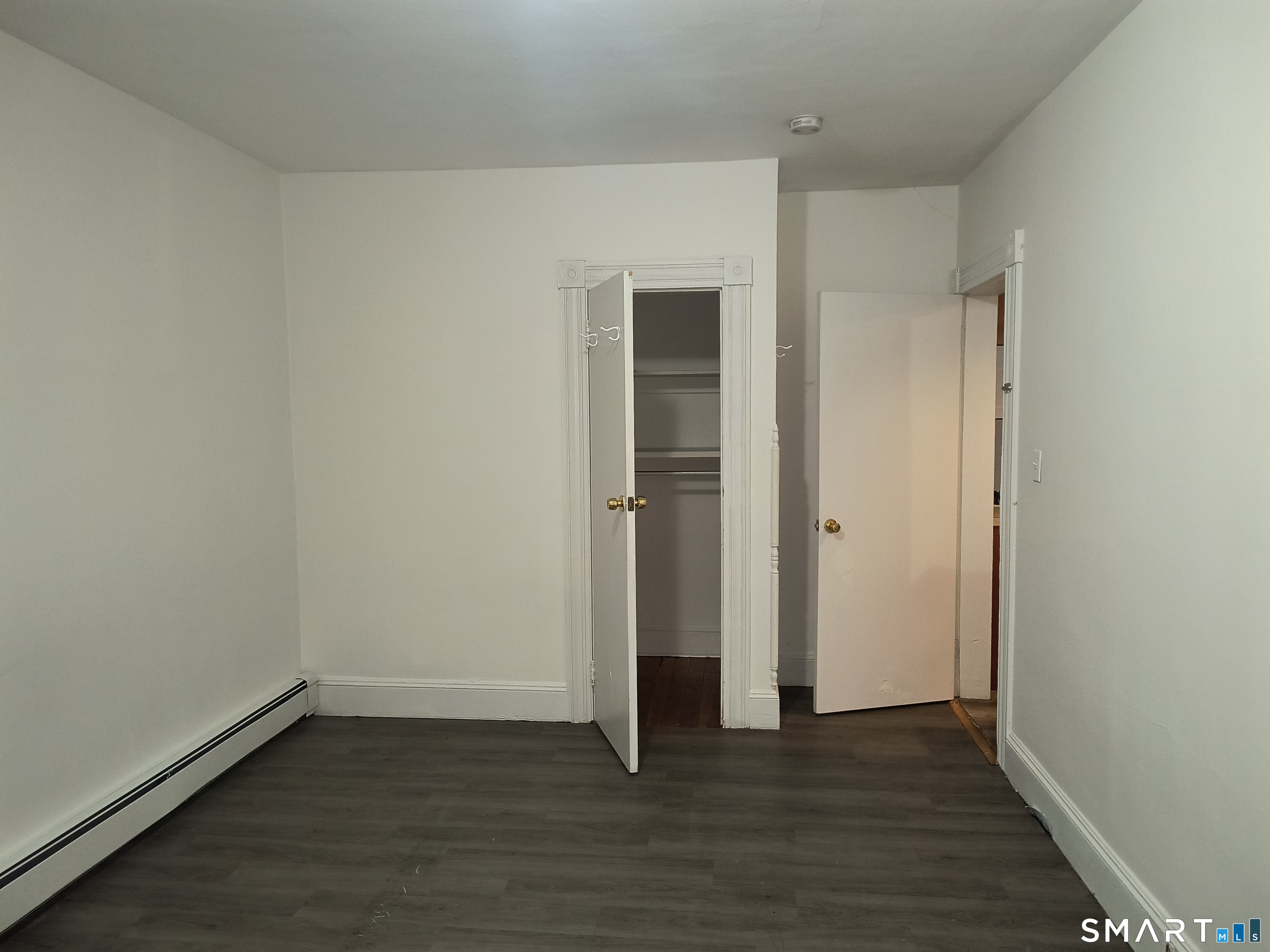 318 Center Street Bridgeport, CT 06604 - Photo 5 of 9 an empty room with wooden floor and closet