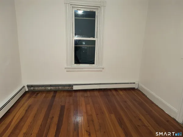 a view of a room with wooden floors and white walls