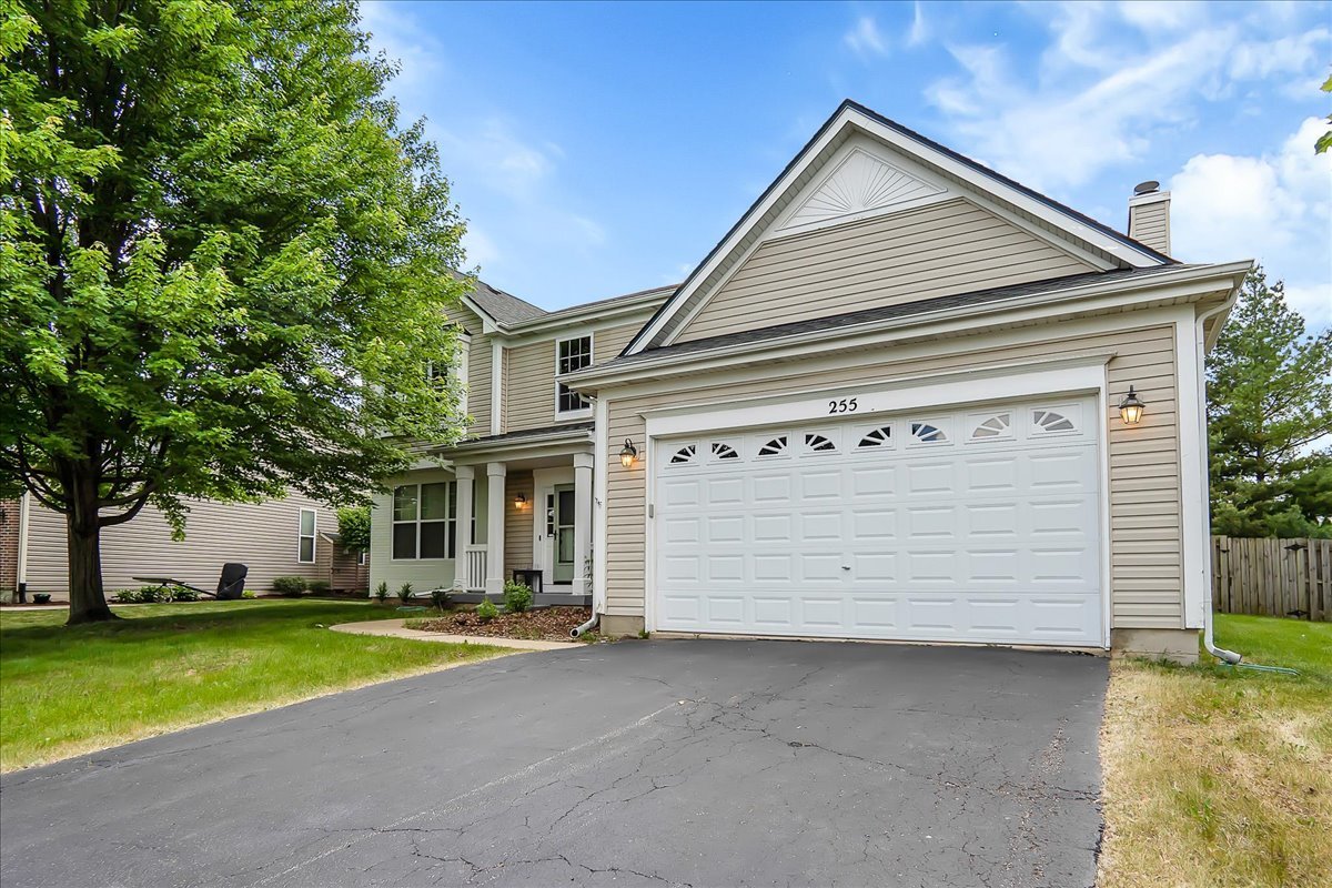 a view of a house with a yard and garage