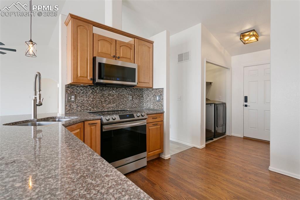 8946 Oakmont Road Peyton, CO 80831 - Photo 11 of 35 a kitchen with granite countertop a stove and a microwave