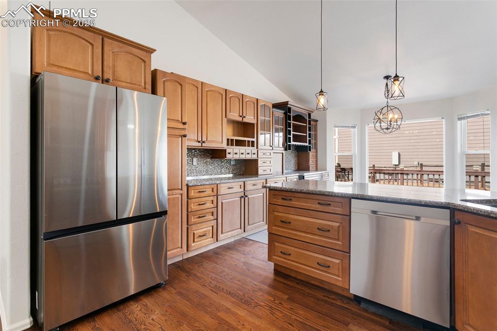 8946 Oakmont Road Peyton, CO 80831 - Photo 14 of 35 a kitchen with stainless steel appliances a refrigerator stove microwave and cabinets