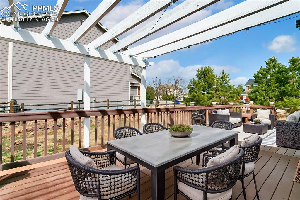 8946 Oakmont Road Peyton, CO 80831 - Photo 32 of 35 a balcony with wooden floor table and chairs