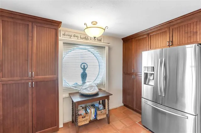 a kitchen with stainless steel appliances a refrigerator and a hard wood floor