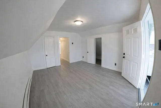 a view of a room with wooden floor and white walls