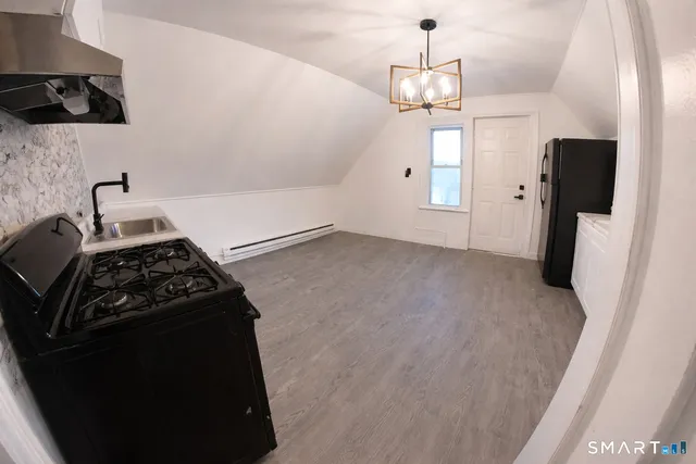 a kitchen with stainless steel appliances a refrigerator a stove a sink and a window