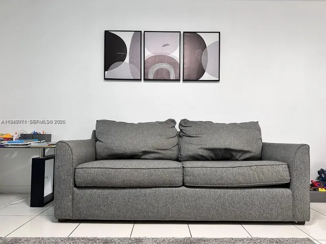 a living room with furniture and wall painting
