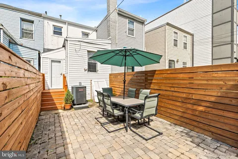 a view of a patio with a table and chairs under an umbrella
