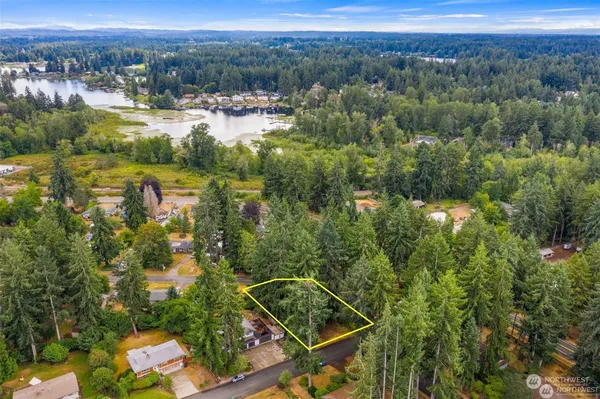 an aerial view of residential houses with outdoor space and trees