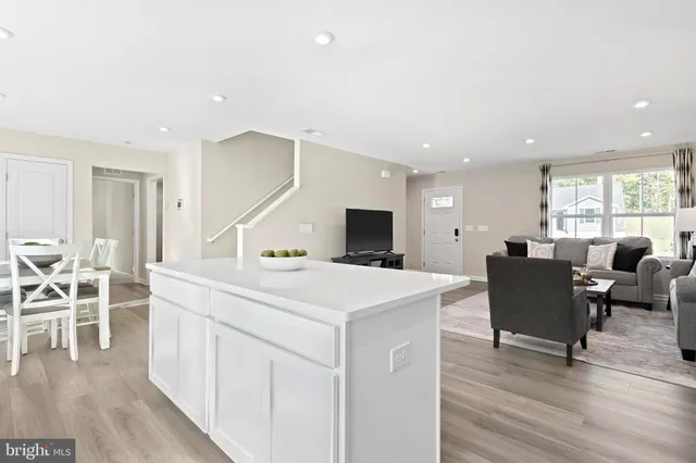 a living room with furniture a wooden floor and a flat screen tv