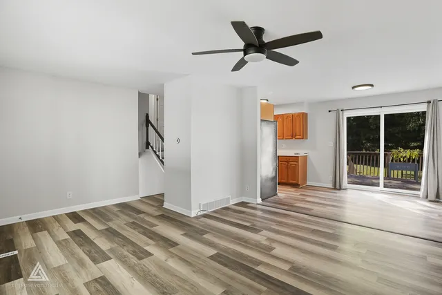 a view of a livingroom with wooden floor and a ceiling fan