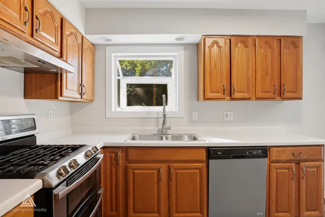 a kitchen with stainless steel appliances granite countertop a sink stove and cabinets