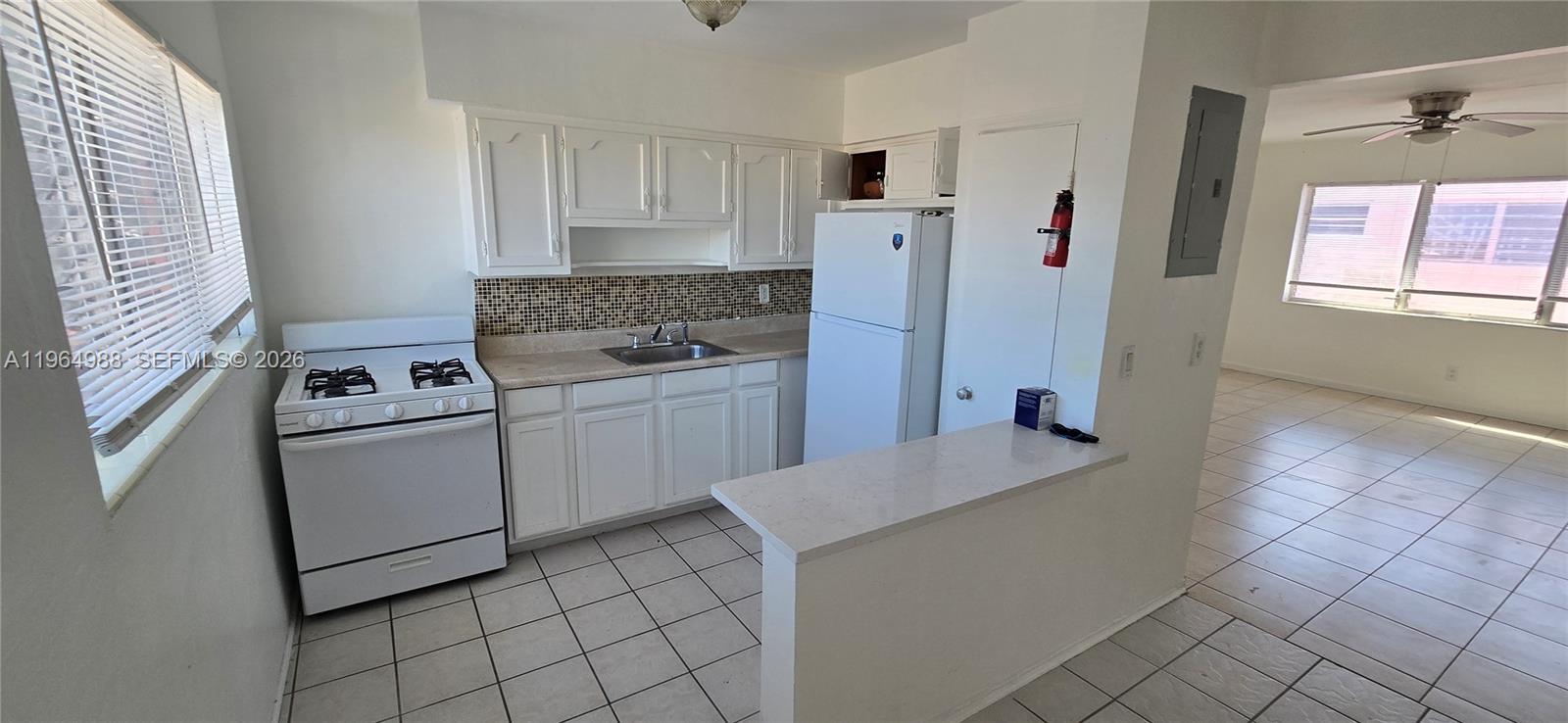 744 85th Street, Unit 1 Miami Beach, FL 33141 - Photo 6 of 17 a kitchen that has a sink and a stove in it