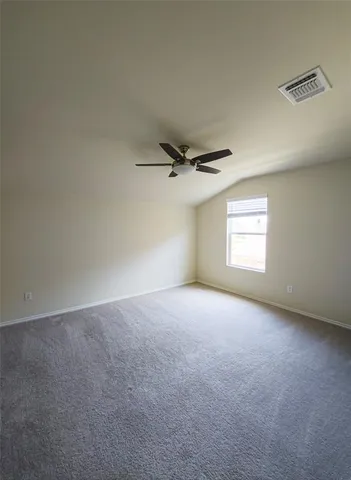 an empty room with a window and a ceiling fan