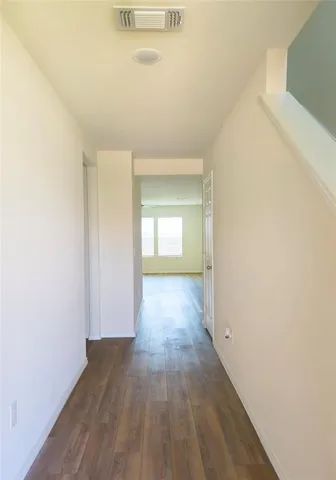 a view of a room with wooden floor and a window
