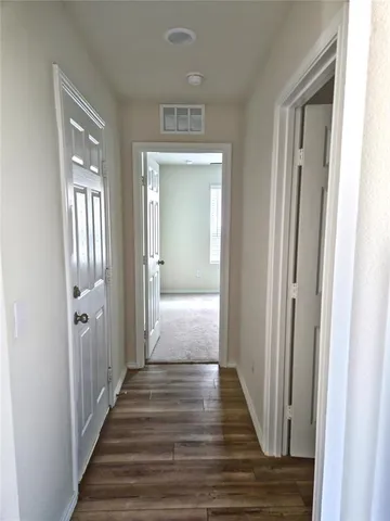 a view of a hallway with wooden floor and closet area