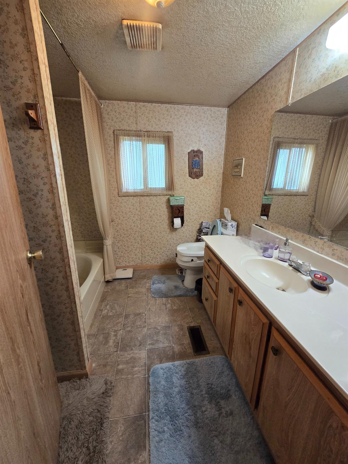 18717 Mill Villa Road, Unit 122 Jamestown, CA 95327 - Photo 14 of 14 a spacious bathroom with a double vanity sink a toilet and a mirror
