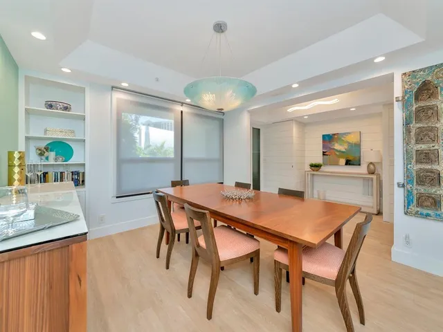 a living room with white cabinets and chandelier