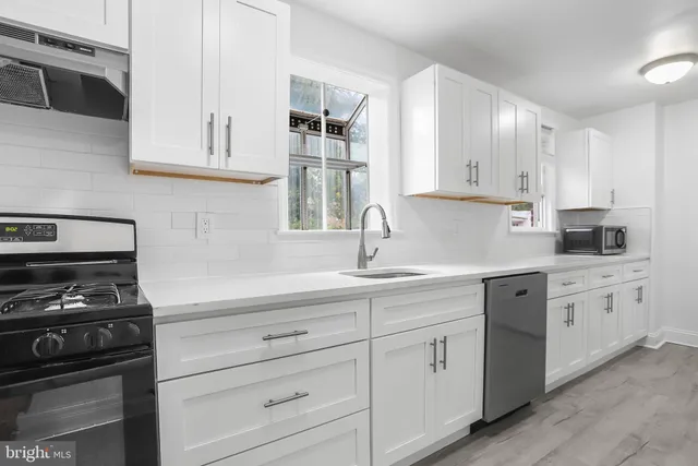 a kitchen with white cabinets and white appliances