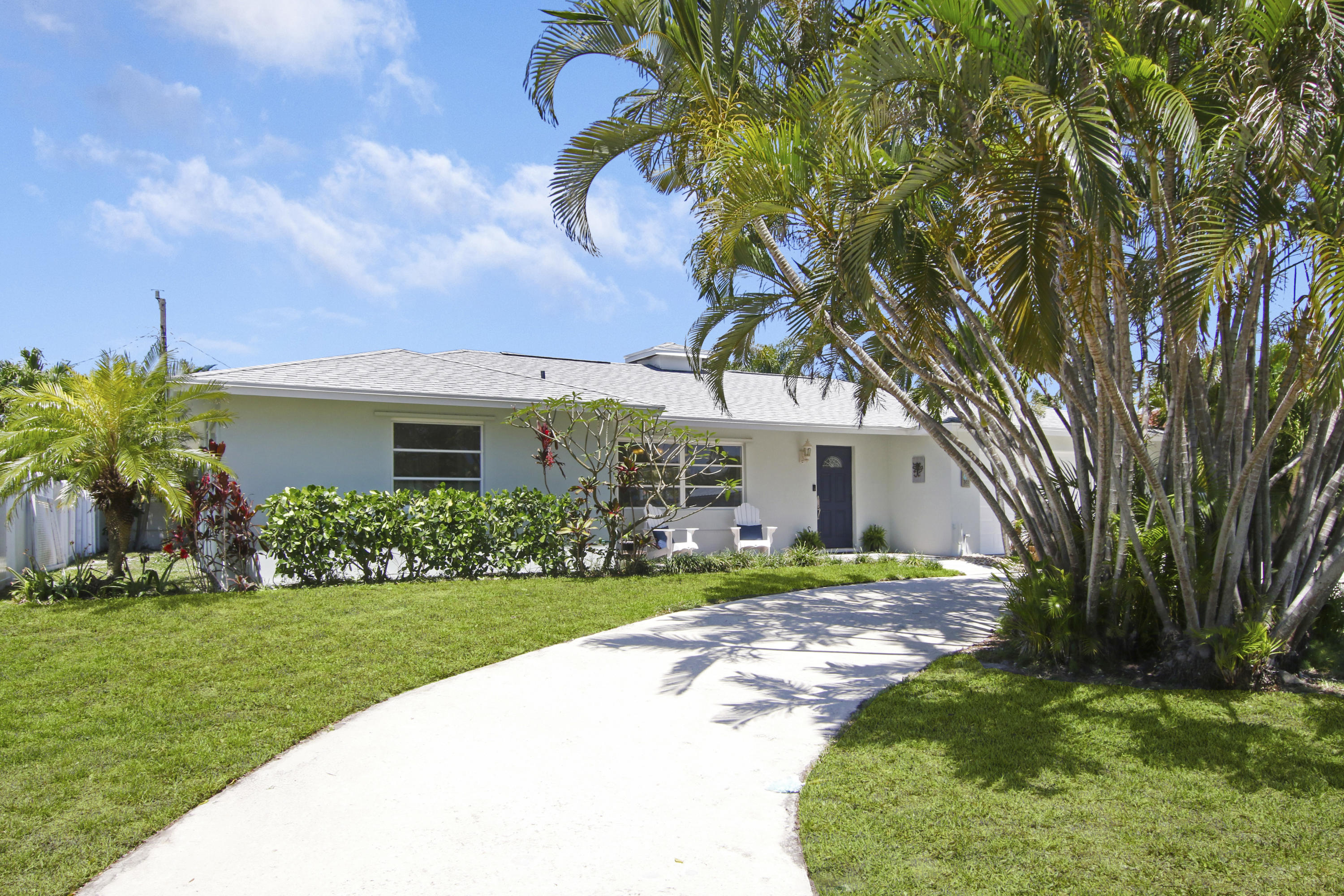 361 Mars Avenue Tequesta, FL 33469 - Photo 2 of 28 a front view of a house with a yard and garage