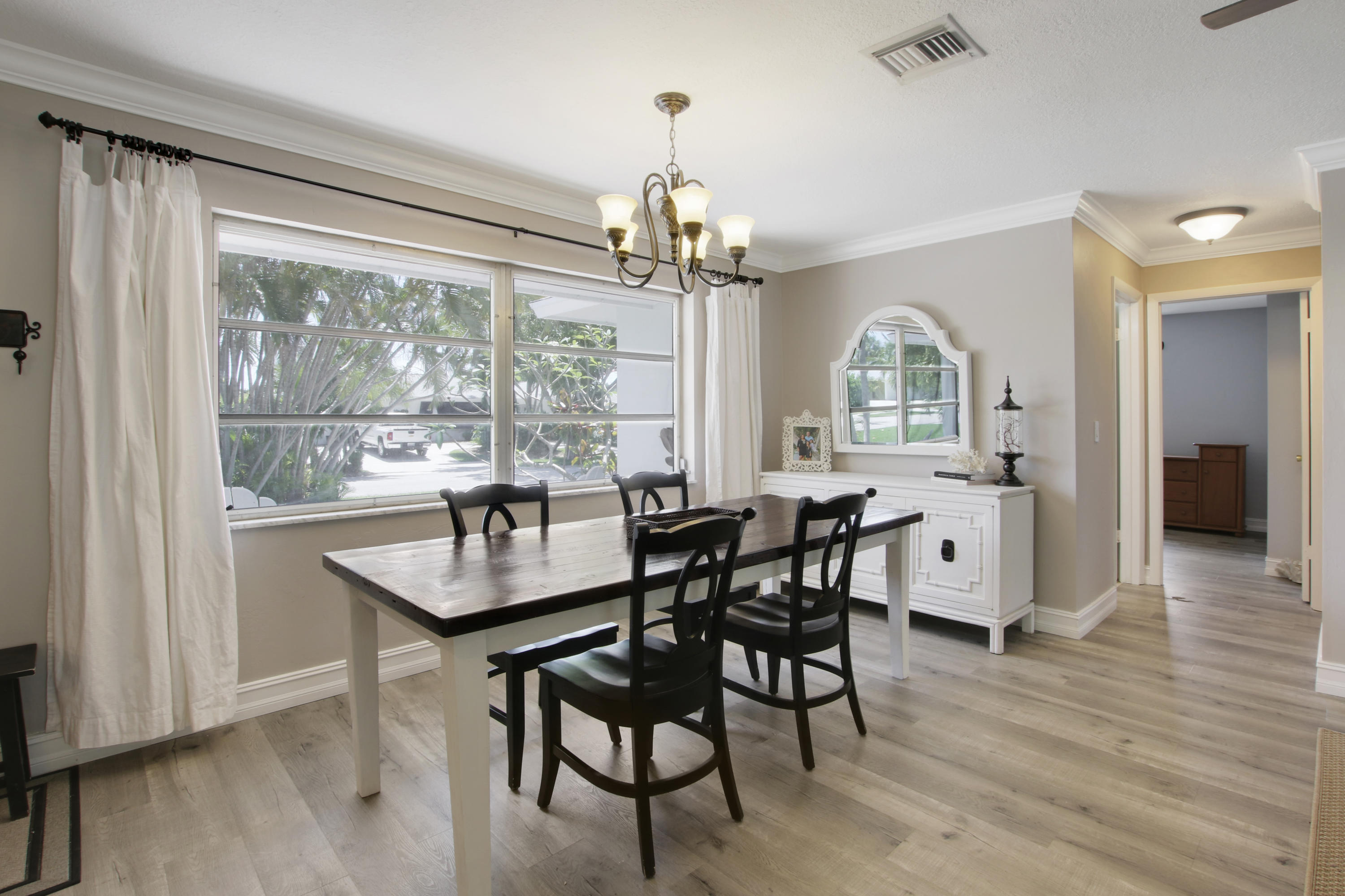 361 Mars Avenue Tequesta, FL 33469 - Photo 9 of 28 a dining room with wooden floor a chandelier a wooden table and chairs