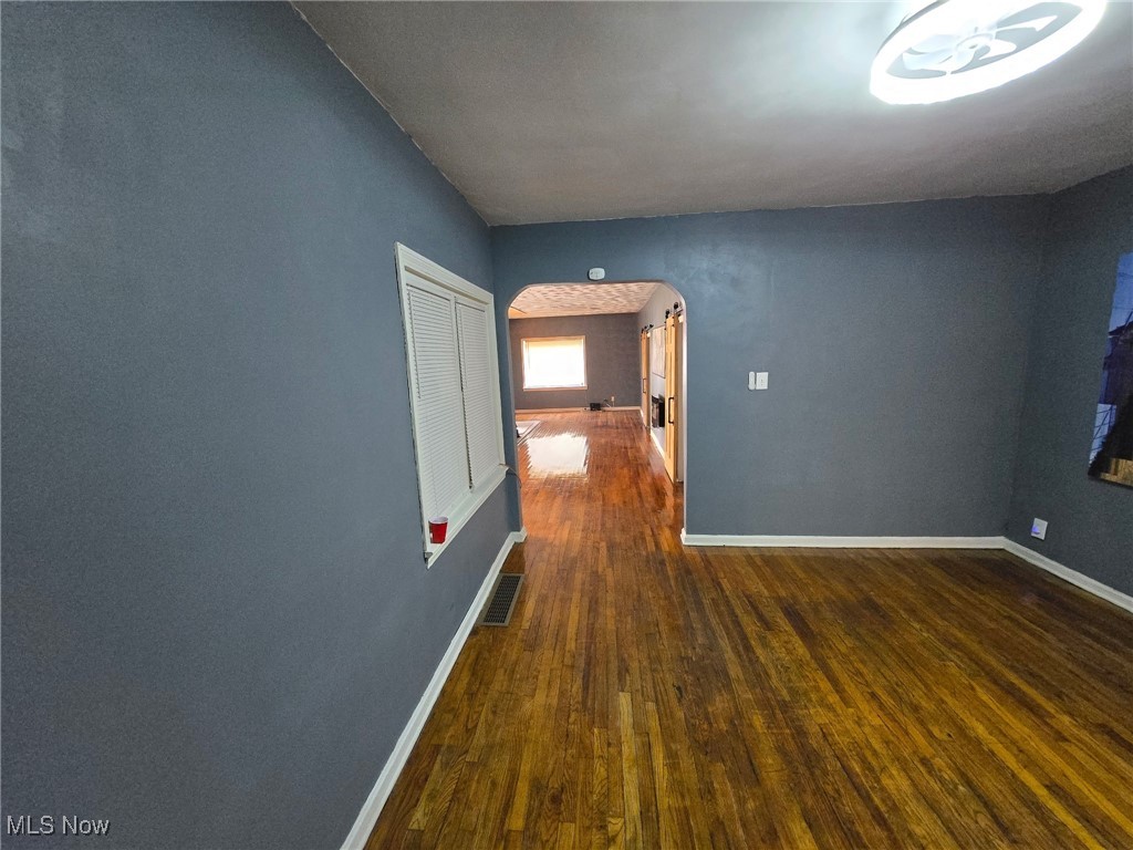 1264 Diagonal Road Akron, OH 44320 - Photo 10 of 23 Unfurnished room with arched walkways, hardwood / wood-style flooring, and baseboards