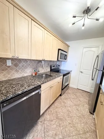a kitchen with stainless steel appliances granite countertop a sink stove and cabinets
