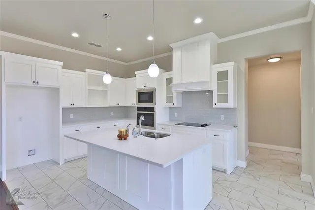 a kitchen with stainless steel appliances kitchen island granite countertop a sink and cabinets