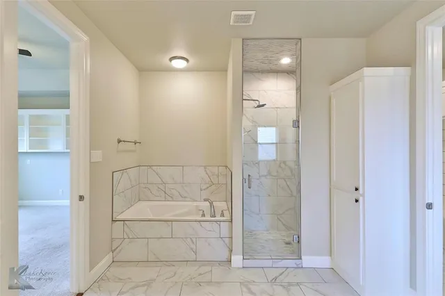 a bathroom with a glass shower door and a bathroom