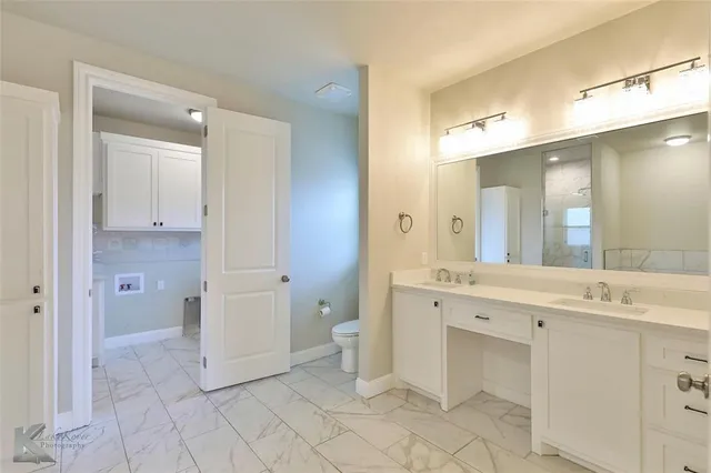 a spacious bathroom with a granite countertop sink mirror and a