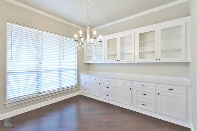 a living room with a large window cabinets and chandelier