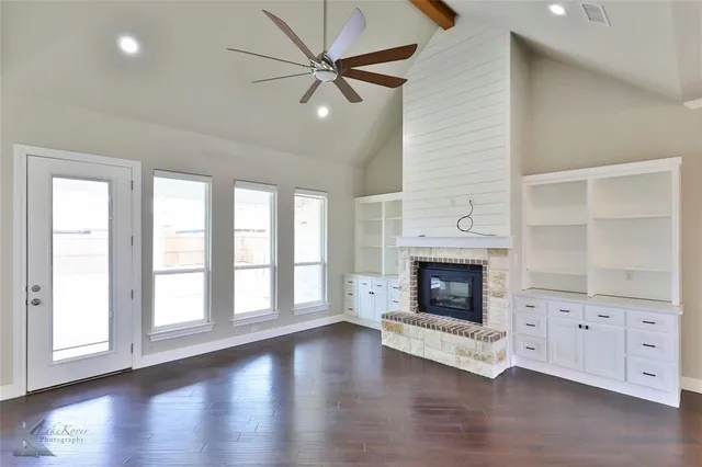 wooden floor fireplace and windows in an empty room