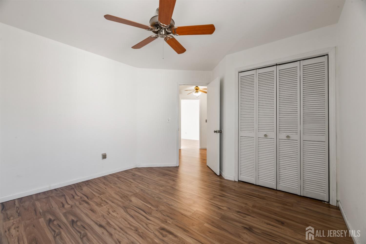 95 Lawrence Street New Brunswick, NJ 08901 - Photo 12 of 25 an empty room with wooden floor fan and windows