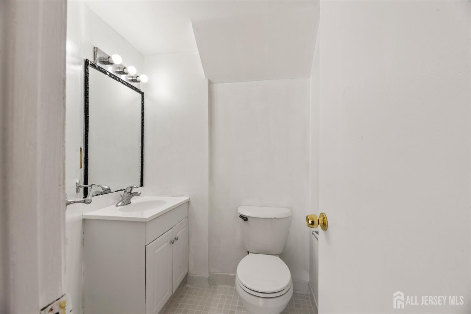 95 Lawrence Street New Brunswick, NJ 08901 - Photo 15 of 25 a bathroom with a toilet a sink and mirror