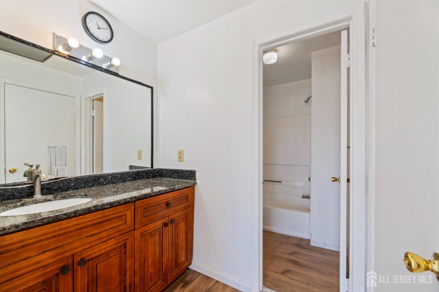 95 Lawrence Street New Brunswick, NJ 08901 - Photo 17 of 25 a bathroom with a granite countertop sink and a mirror