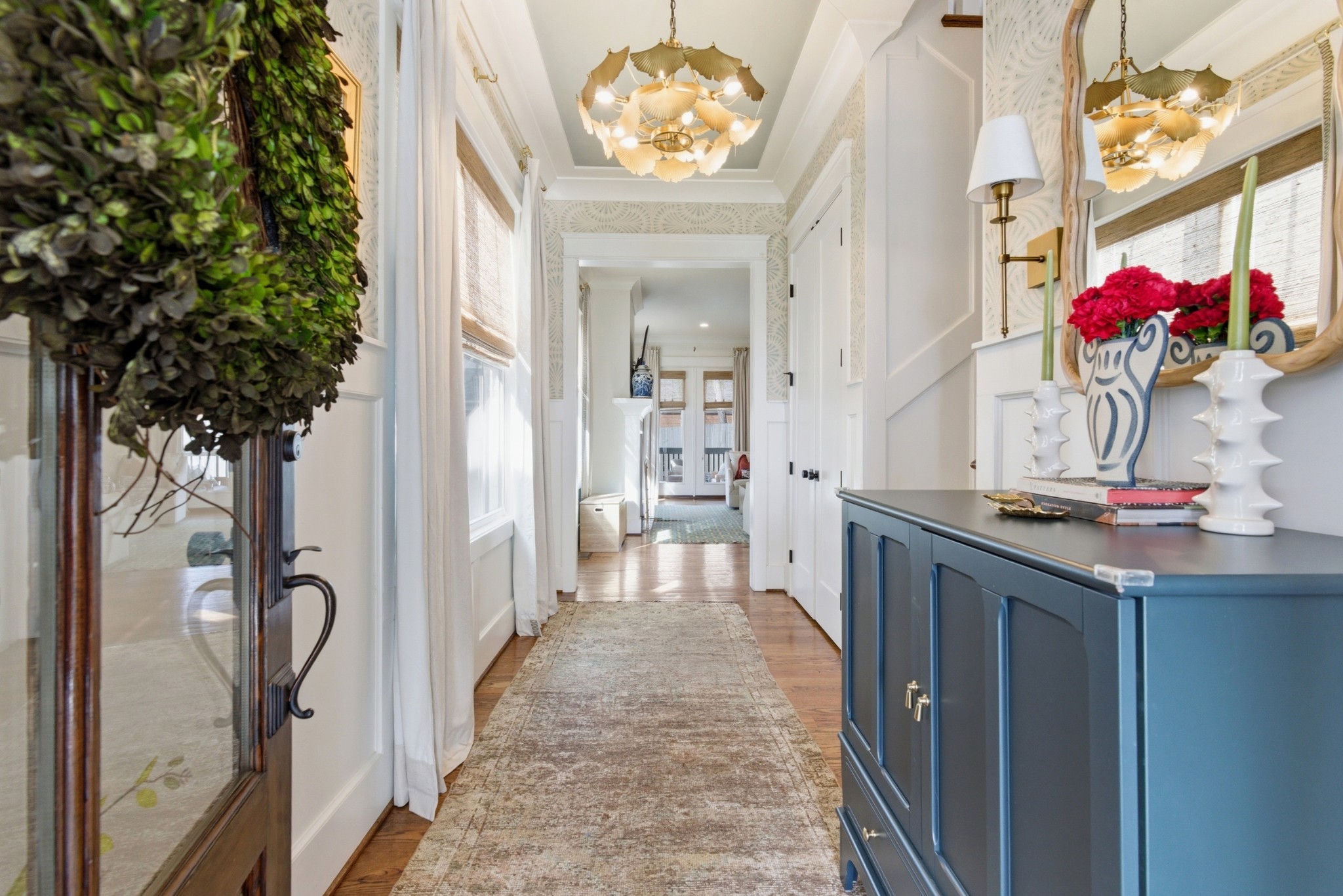 a hallway with a chandelier and a table