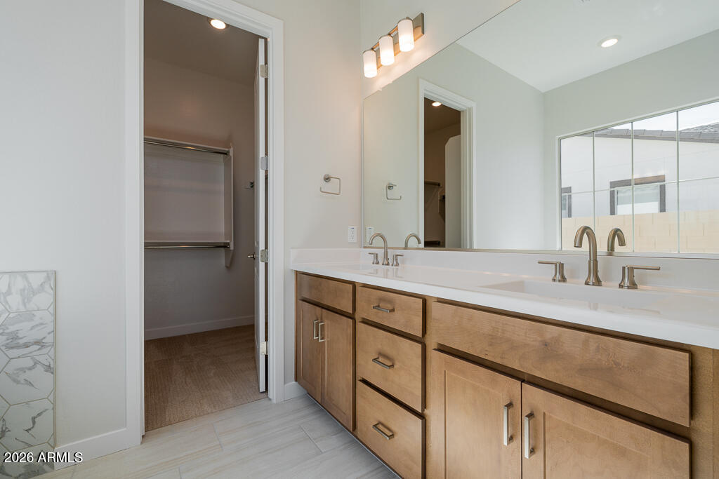 5879 South Red Rock Street Gilbert, AZ 85298 - Photo 7 of 18 a bathroom with a double vanity sink and mirror