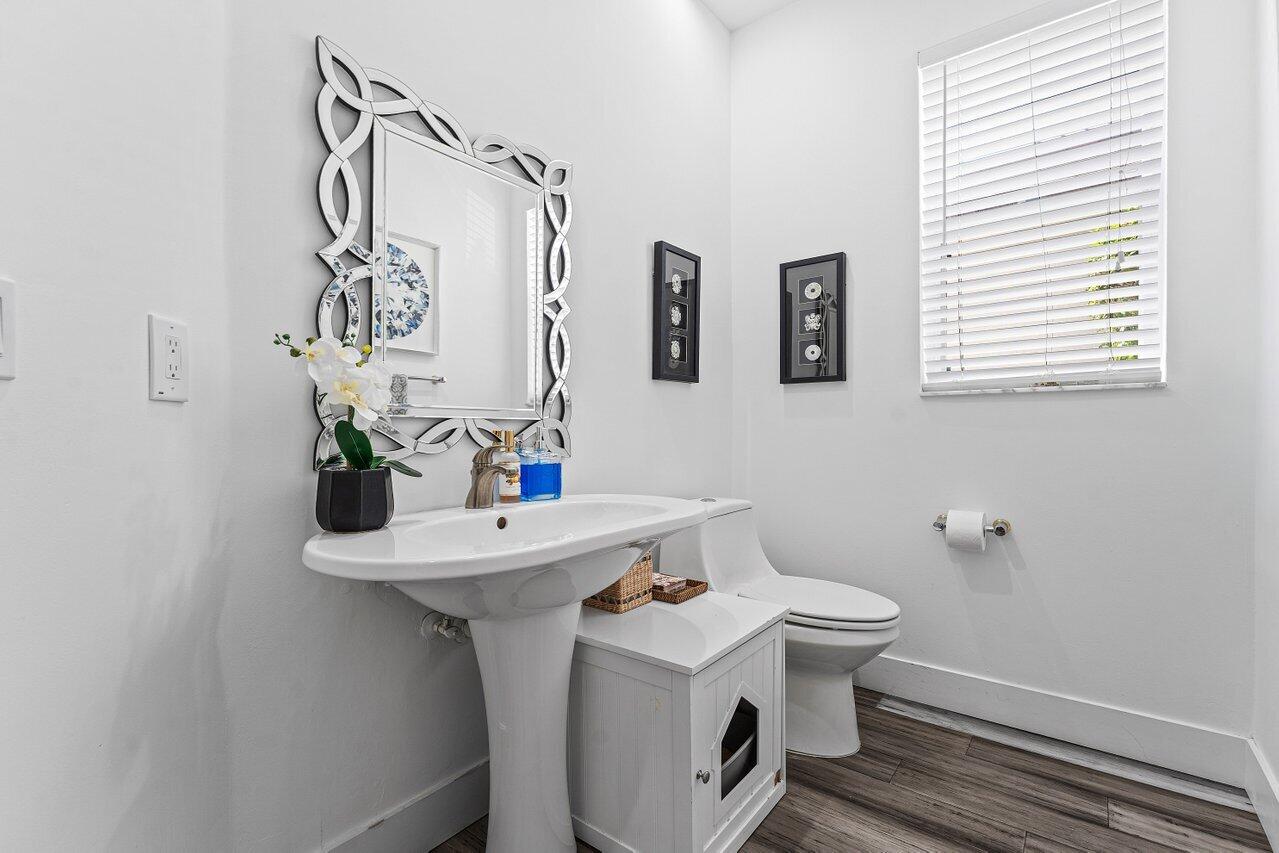 3395 Northwest 53rd Circle Boca Raton, FL 33496 - Photo 21 of 64 a bathroom with a sink a toilet and mirror