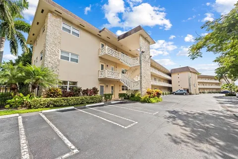 a front view of a house with a garden and trees