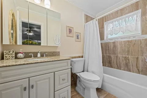 a bathroom with a granite countertop toilet sink and mirror